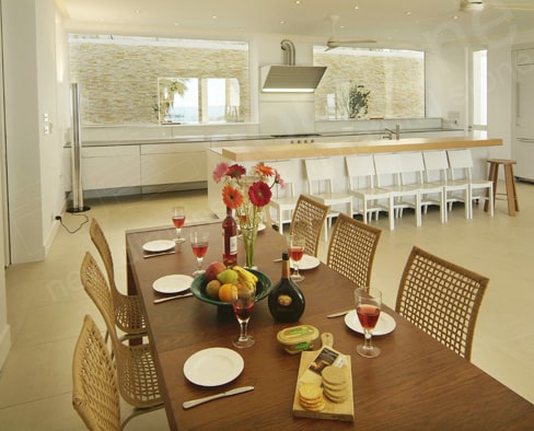 Norstone Ivory Rock Panels visible through two large panoramic glass windows in an open concept kitchen and dining room